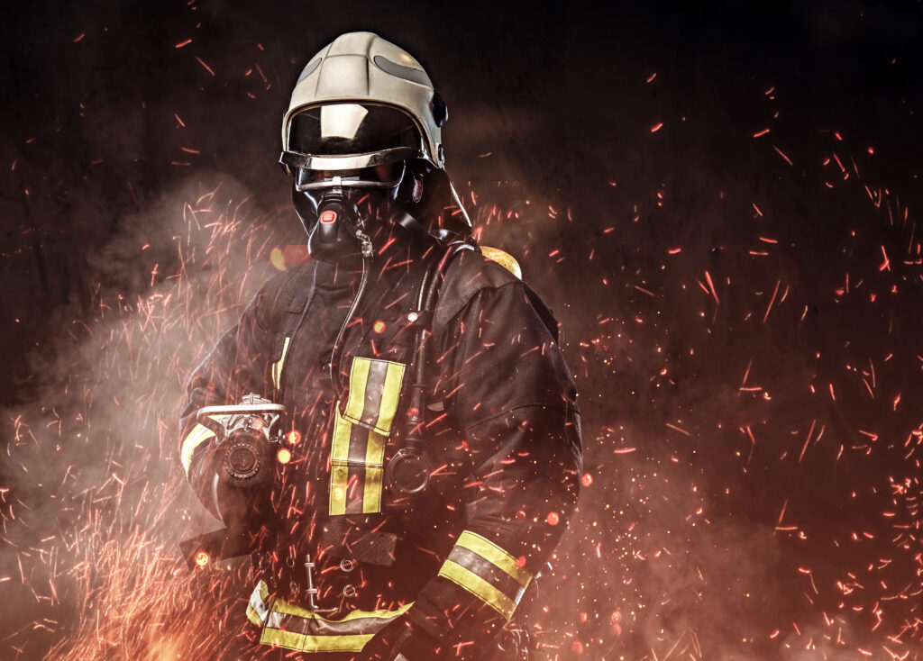 a firefighter dressed in a uniform in a studio.